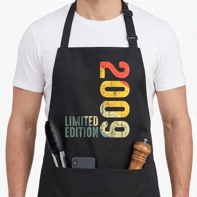 Tablier de cuisine noir avec l'année 2009 imprimée verticalement en couleurs délavées et Limited Edition en bas à gauche.