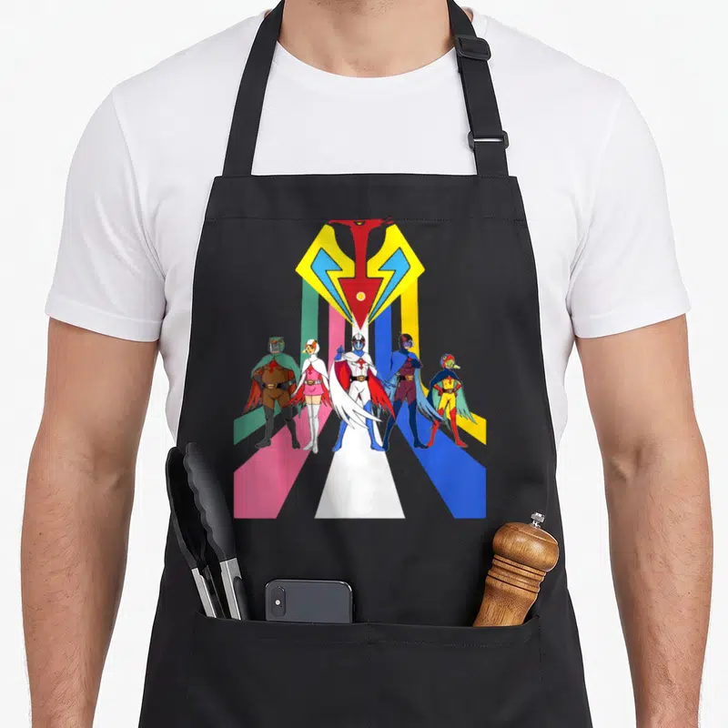 Tablier de cuisine noir avec illustration colorée du groupe Gatachaman et logo géométrique sur fond de rayons multicolores.