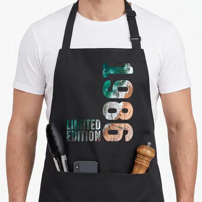 Tablier de cuisine noir avec grand 1986 stylisé vagues et texte Limited Edition en bas à gauche.