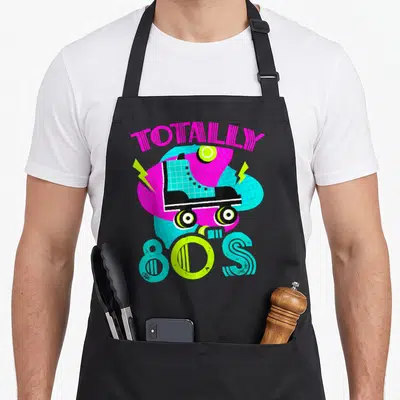 Tablier de cuisine noir avec une patinette rose et le texte Totally 80s en lettres colorées.