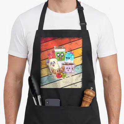 Tablier de cuisine noir avec un petit déjeuner rétro kawaii graphique illustrant des aliments anthropomorphes souriants sur fond rayé coloré.