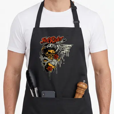 Tablier de cuisine noir avec tête de mort biker casque ailes pistons et roses rouges style vintage.