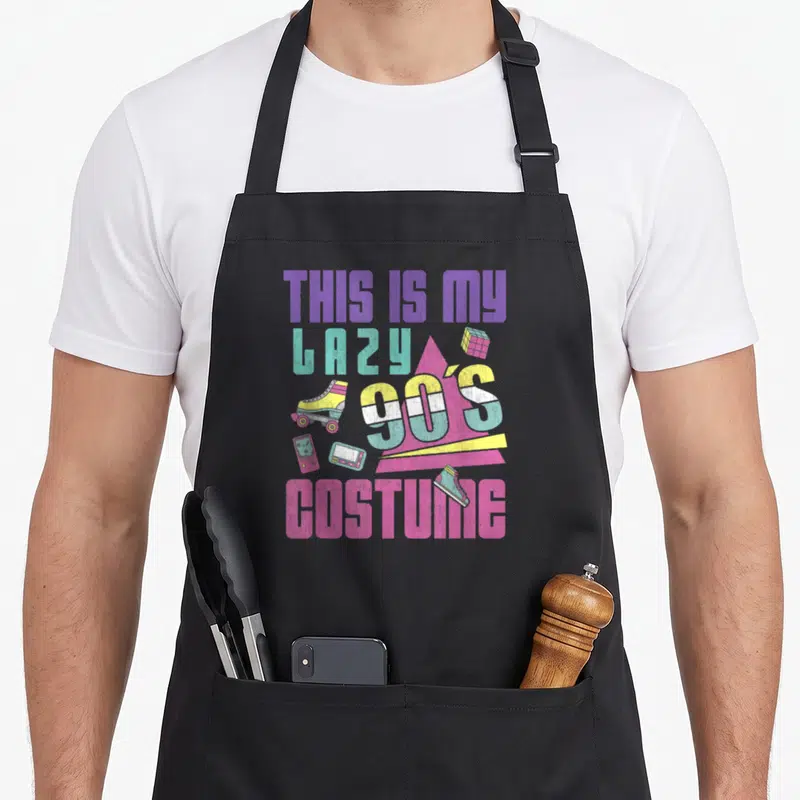 Tablier de cuisine noir avec illustration colorée Patins à roulettes, console portable et texte This Is My Lazy 90's Costume.