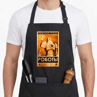 Tablier de cuisine noir avec illustration retro d'un robot soviétique et texte Kamrady Stal Roboty en aquarelle orange.