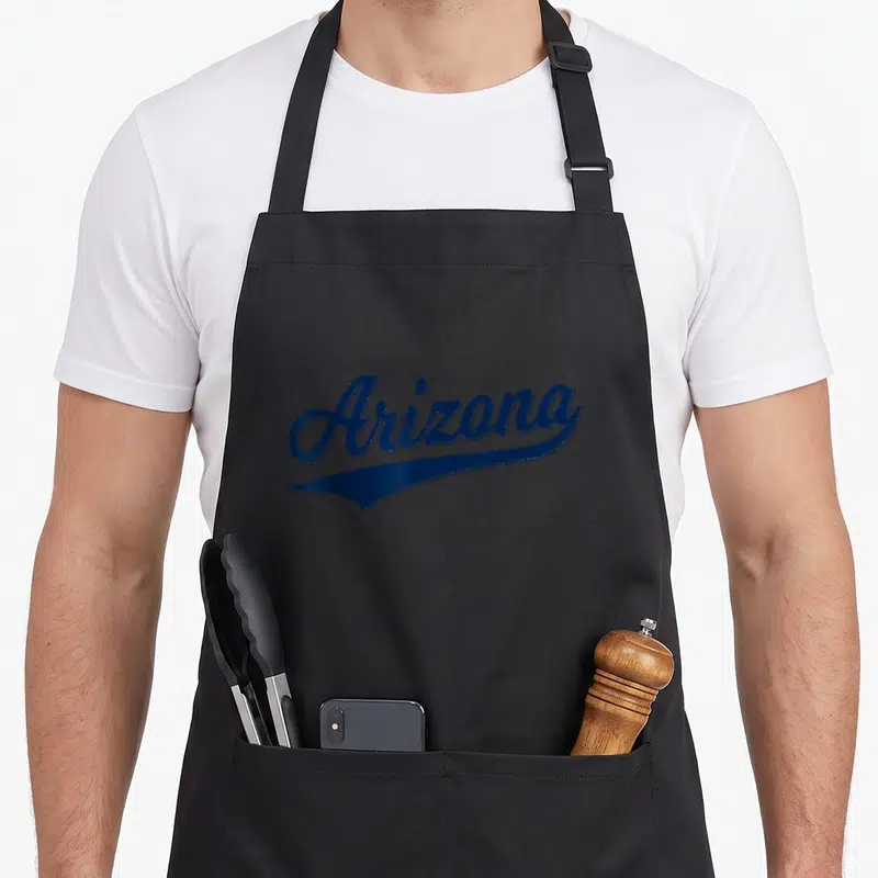 Tablier de cuisine noir avec l'inscription Arizona en bleu style Varsity rétro et une ligne soulignante sous le texte.