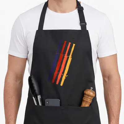 Tablier de cuisine noir avec quatre bassons stylisés en bleu, rouge, orange et jaune disposés en diagonale.