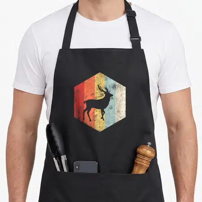 Tablier de cuisine noir avec silhouette d'élan dans un hexagone coloré style rétro.