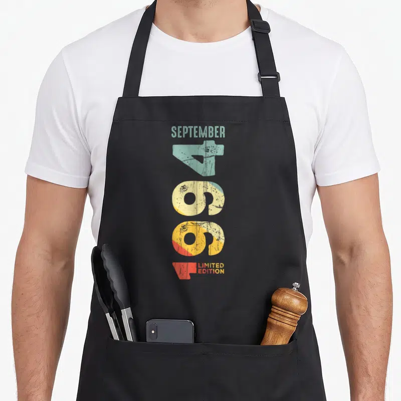 Tablier de cuisine noir avec l'inscription Septembre 1994 et Millésime 1994 en typographie rétro colorée et texturée.