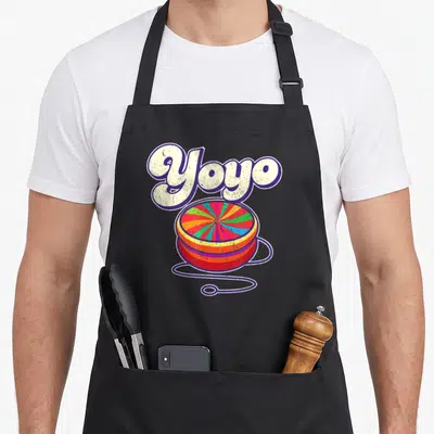 Tablier de cuisine noir avec illustration colorée d'un yoyo rétro et le mot Yoyo en lettres capitales blanches à contour violet.