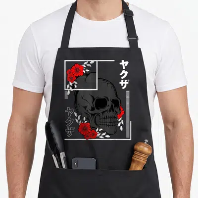 Tablier de cuisine noir avec tête de mort, roses rouges et inscriptions Kanji Yakuza en blanc.