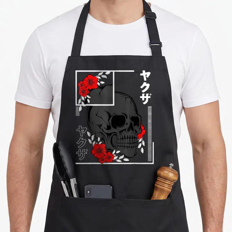 Tablier de cuisine noir avec tête de mort, roses rouges et inscriptions Kanji Yakuza en blanc.