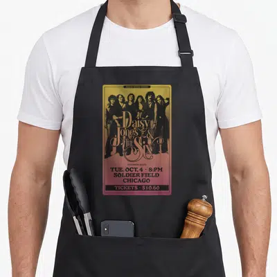 Tablier de cuisine noir avec une affiche de concert retro Daisy Jones et The Six à Chicago sur fond dégradé jaune et rose.