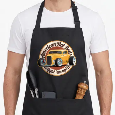 Tablier de cuisine noir avec illustration circulaire d'une hotrod jaune et du texte American Hot Rod Light em up.