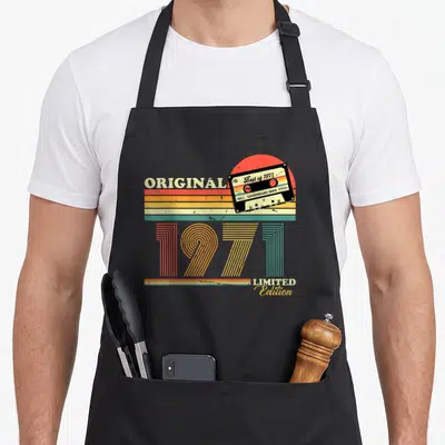 Tablier de cuisine noir avec illustration cassette audio 1971 et texte original limited edition coloré.