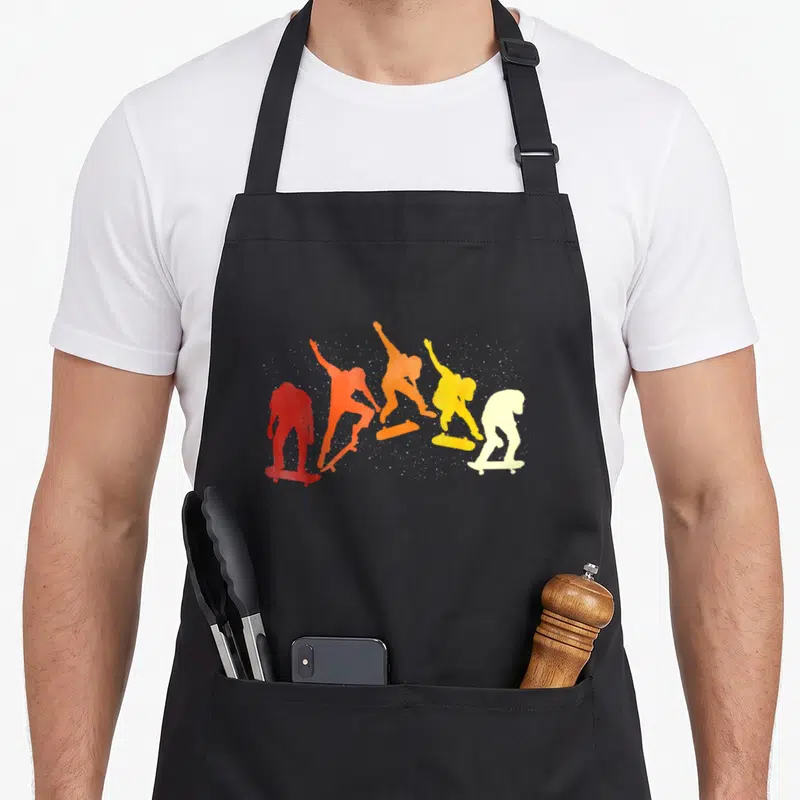 Tablier de cuisine noir avec silhouettes de skateurs colorées en dégradé rétro.
