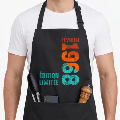 Tablier de cuisine noir avec inscription verticale 1968 et texte édition spéciale en orange et turquoise.