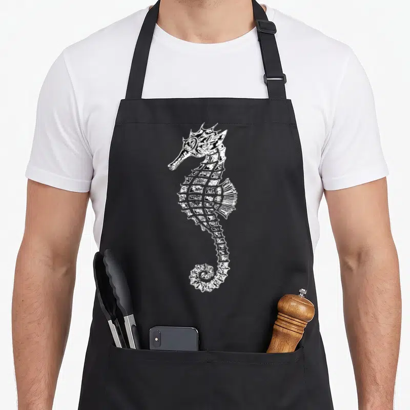 Tablier de cuisine noir avec illustration blanche d'un hippocampe au style rétro et détaillé