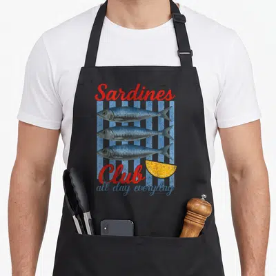 Tablier de cuisine noir avec illustration de trois sardines, texte rouge et quartier de citron jaune.
