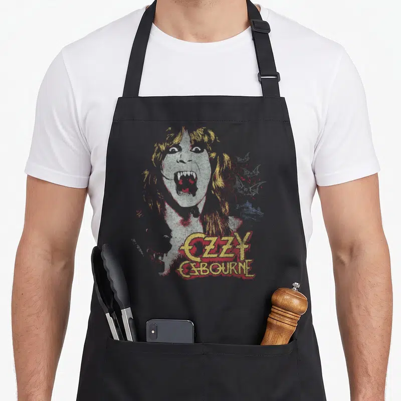 Tablier de cuisine noir avec portrait vampire Ozzy Osbourne et texte doré rouge dégradé style vintage.
