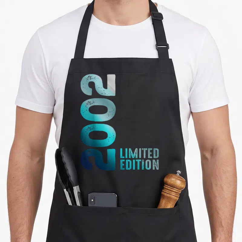 Tablier de cuisine noir avec l'année 2002 en bleu vertical et le texte Limited Edition à côté.