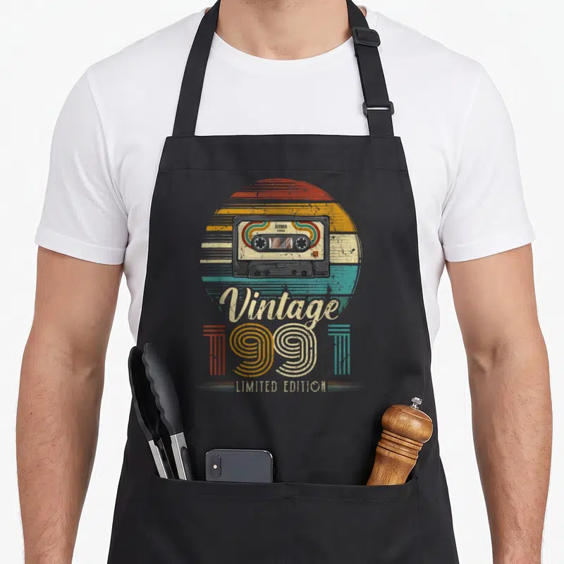 Tablier de cuisine noir avec illustration de cassette Stereo Vintage 1991 Limited Edition et soleil rétro coloré.
