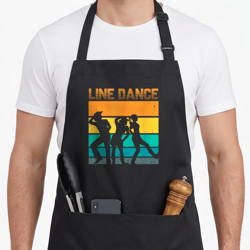 Tablier de cuisine noir avec illustration rétro de trois silhouettes dansant en ligne sur bandes orange jaune et turquoise.