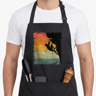 Tablier de cuisine noir avec silhouette grimpeur bouldering sur fond de bandes colorées vintage délavées.