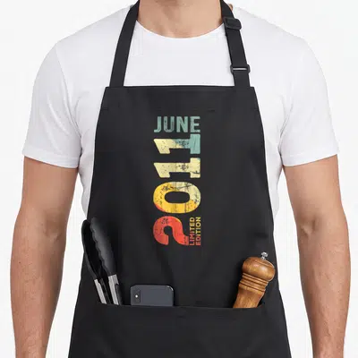 Tablier de cuisine noir avec typographie verticale colorée Juin 2011 et Limited Edition en style rétro délavé.