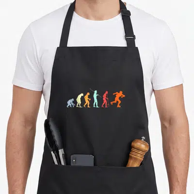 Tablier de cuisine noir avec illustration colorée de l'évolution humaine terminant par un patineur sur roulettes.