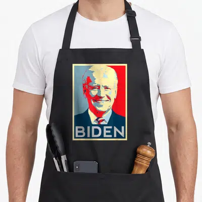 Tablier de cuisine noir avec un portrait stylisé de Joe Biden et l'inscription BIDEN en bas.