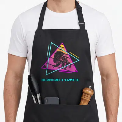 Tablier de cuisine noir avec illustration géométrique colorée et texte Bernard-L'Ermite en cyan pixelisé.