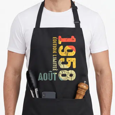 Tablier de cuisine noir avec inscription verticale 1958 Août en lettres délavées orange jaune et bleu turquoise