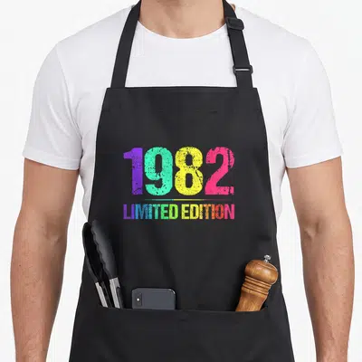 Tablier de cuisine noir avec 1982 Limited Edition imprimé en couleurs vives et style rétro dégradé.