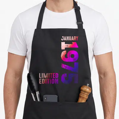 Tablier de cuisine noir avec typographie verticale colorée indiquant janvier 1975 et limited edition en dégradé rose et violet.