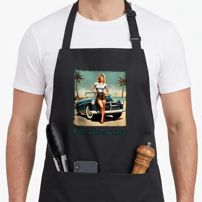 Tablier de cuisine noir avec illustration pin up retro sur roadster bleu et texte old school vacation en bas.