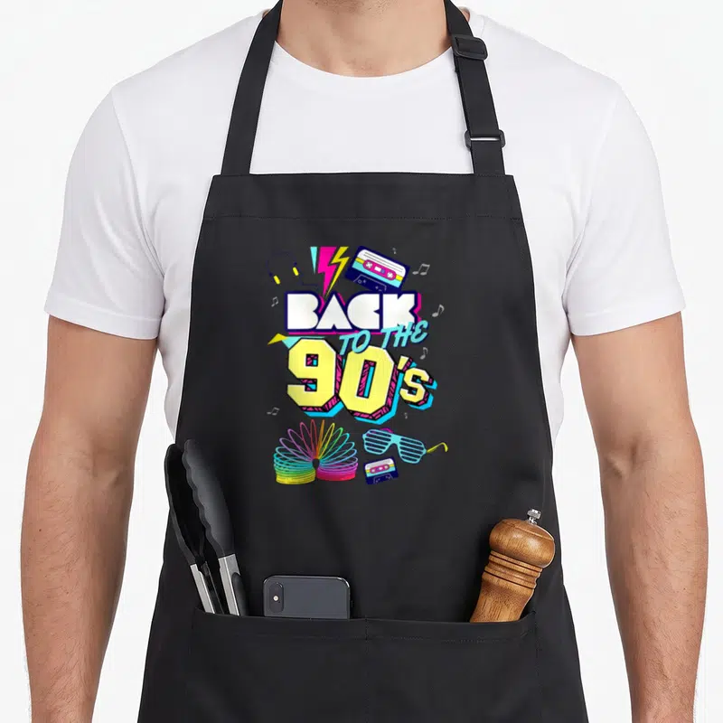 Tablier de cuisine noir avec illustration rétro Back to the 90's, cassette, slinky et lunettes de soleil.