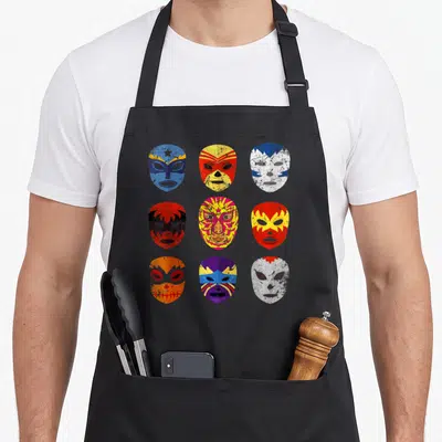 Tablier de cuisine noir avec neuf masques de lucha libre colorés et effet vieilli répartis en grille.
