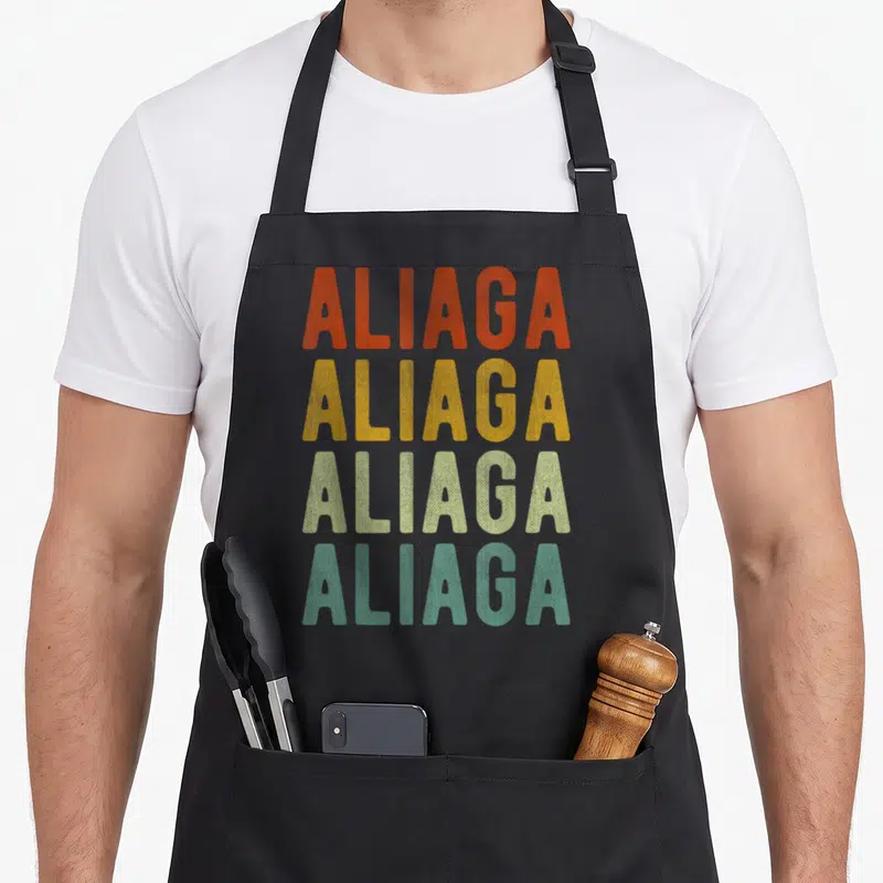 Tablier de cuisine noir avec le texte Aliaga répété quatre fois en orange, jaune, vert clair et turquoise.