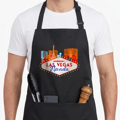 Tablier de cuisine noir avec un motif souvenir vintage représentant le skyline de Las Vegas Nevada en couleurs vives.
