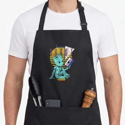 Tablier de cuisine noir avec Baby Groot tenant une cassette et le texte I am GROOT sur fond de soleil rayé jaune.