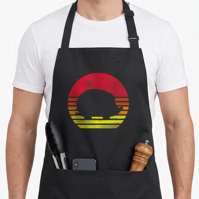 Tablier de cuisine noir avec silhouette de hérisson rétro sur fond de soleil couchant rouge orange et jaune