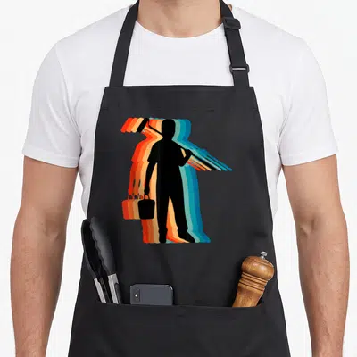 Tablier de cuisine noir avec silhouette de peintre portant un rouleau et un pot, effet décalqué multicolore.