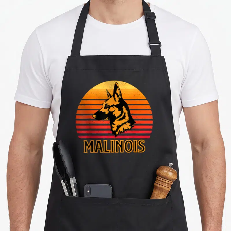 Tablier de cuisine noir avec illustration rétro d'un chien Malinois et le texte MALINOIS en bas.