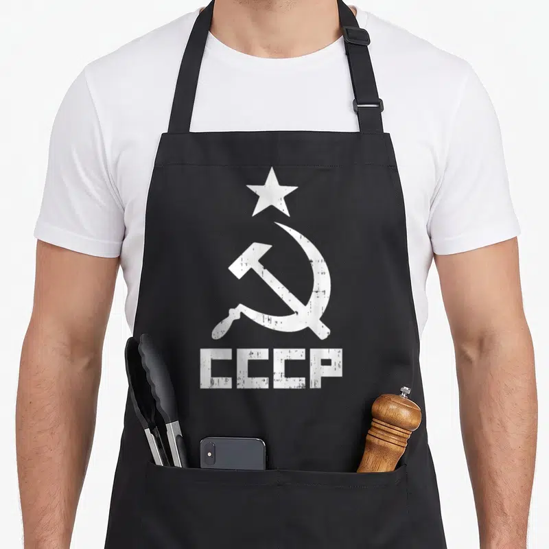 Tablier de cuisine noir avec l'inscription CCCP, une étoile, un marteau et une faucille en blanc délavé.