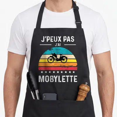 Tablier de cuisine noir avec illustration Mobylette rétro et texte J'peux pas j'ai sur fond de soleil couchant coloré.