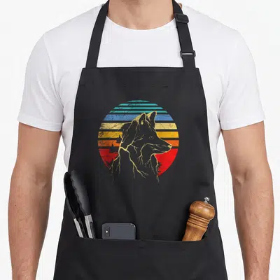 Tablier de cuisine noir avec illustration d'un renard gris sur un soleil rayé bleu jaune et rouge style rétro.
