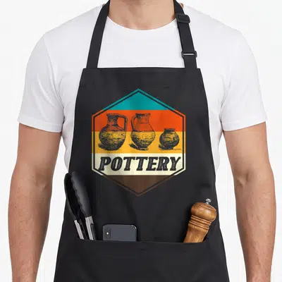 Tablier de cuisine noir avec un logo hexagonal rétro représentant trois vases de poterie gris sur bandes orange jaune et texte POTTERY