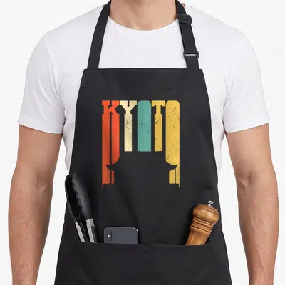 Tablier de cuisine noir avec l'inscription Kyoto en lettres colorées et style vintage texturé