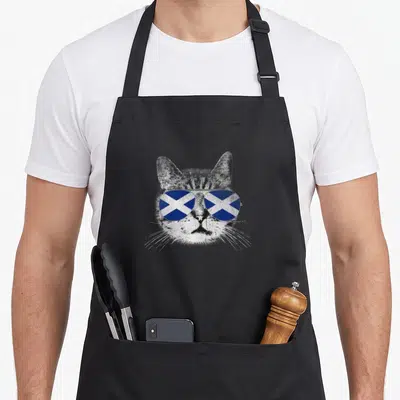 Tablier de cuisine noir avec illustration d'un chat portant des lunettes au drapeau écossais en style rétro.