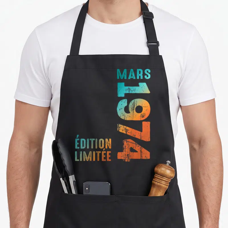Tablier de cuisine noir avec inscription verticale Mars 1974 et « Édition Limitée » en dégradé turquoise orange.